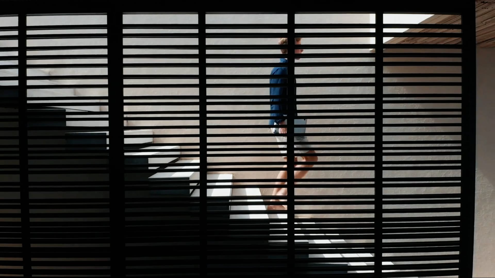 A young man walking down a set of stairs in a villa in Lombok, Indonesia